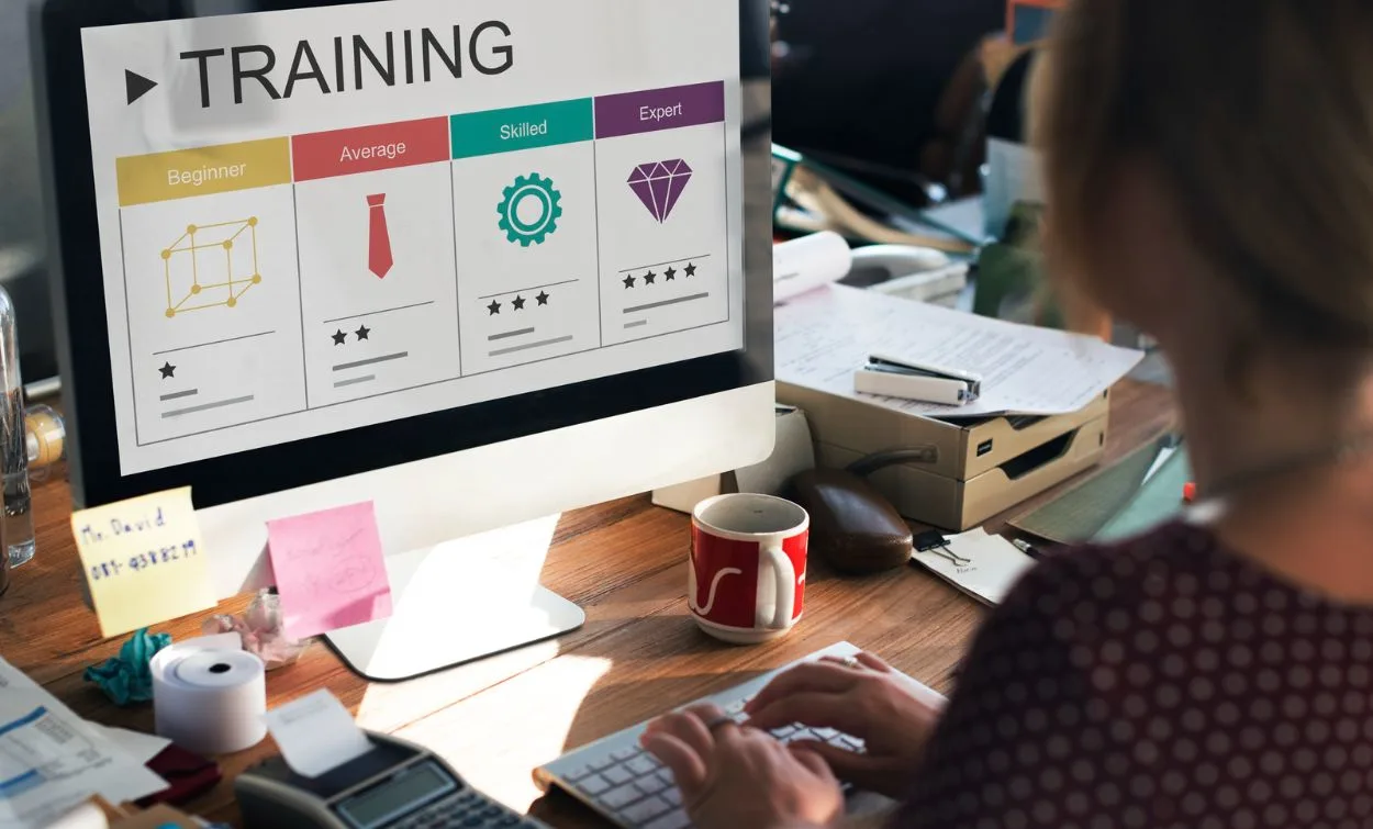 A professional software training environment featuring a learner working at a computer while progressing through different training levels, from beginner to expert. The image represents skill development, technical learning, professional growth, and career-focused software training.